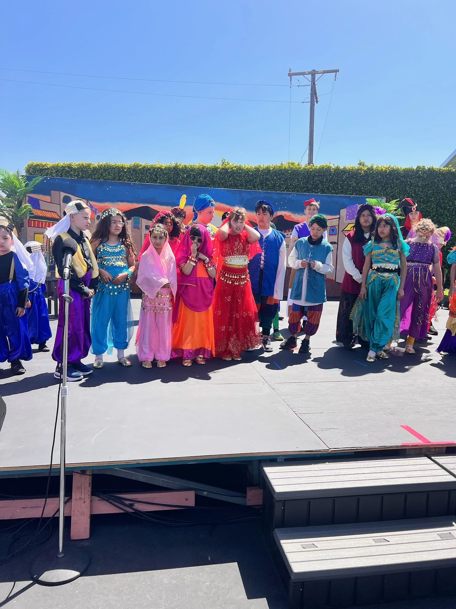 Page Academy students in colorful costumes on the outdoor stage