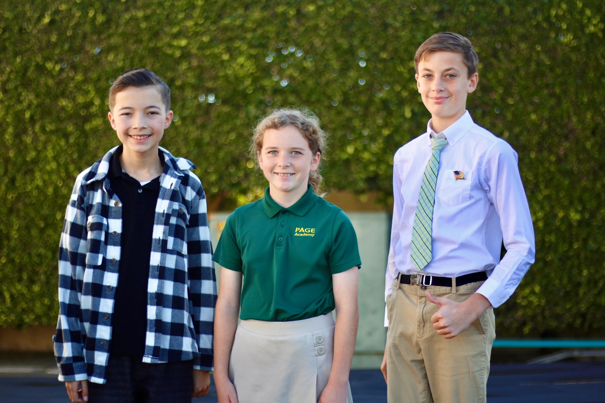 Three Page Academy middle school students standing together on campus