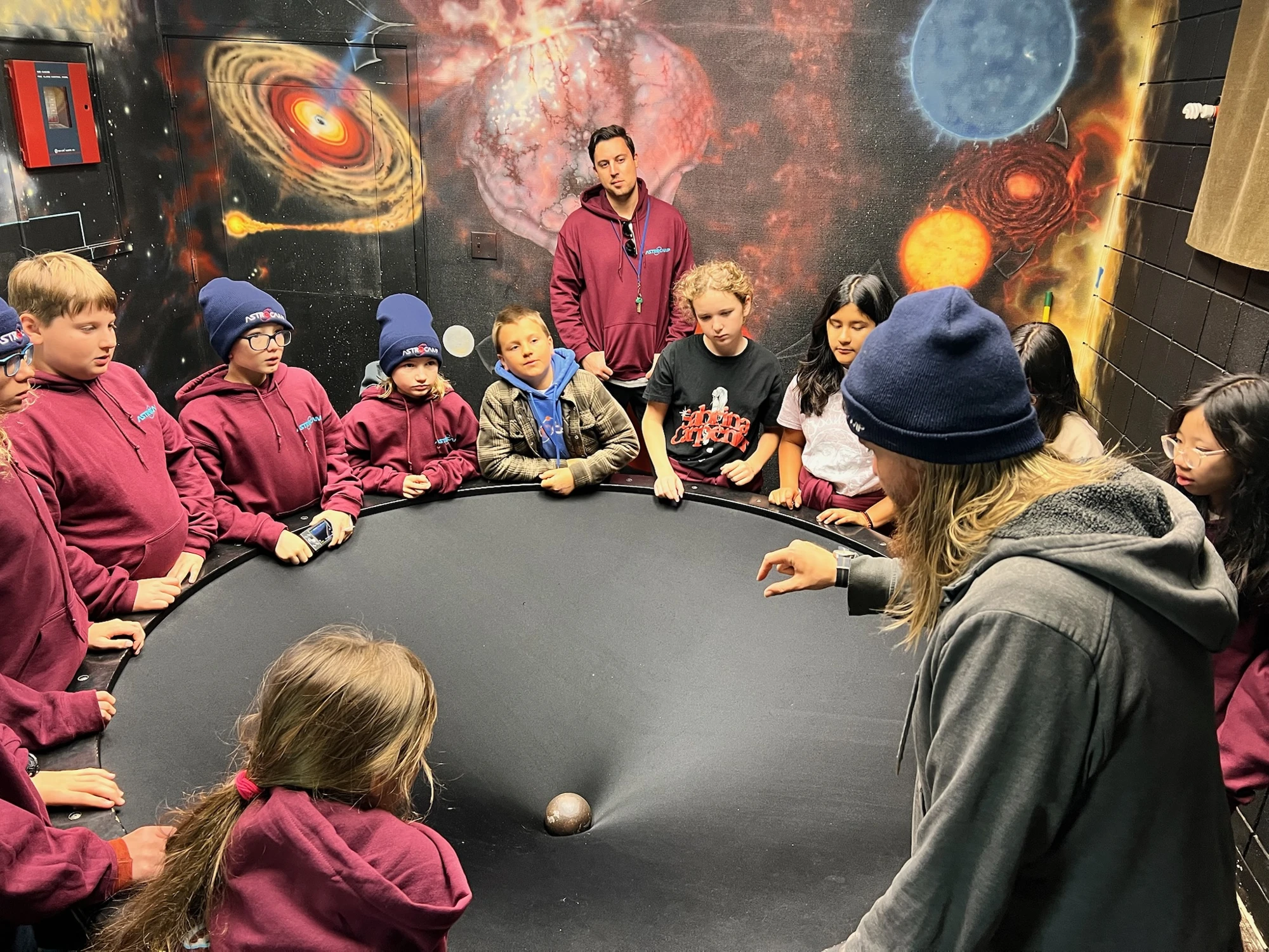 Page Academy students gathered around a gravity demonstration at AstroCamp